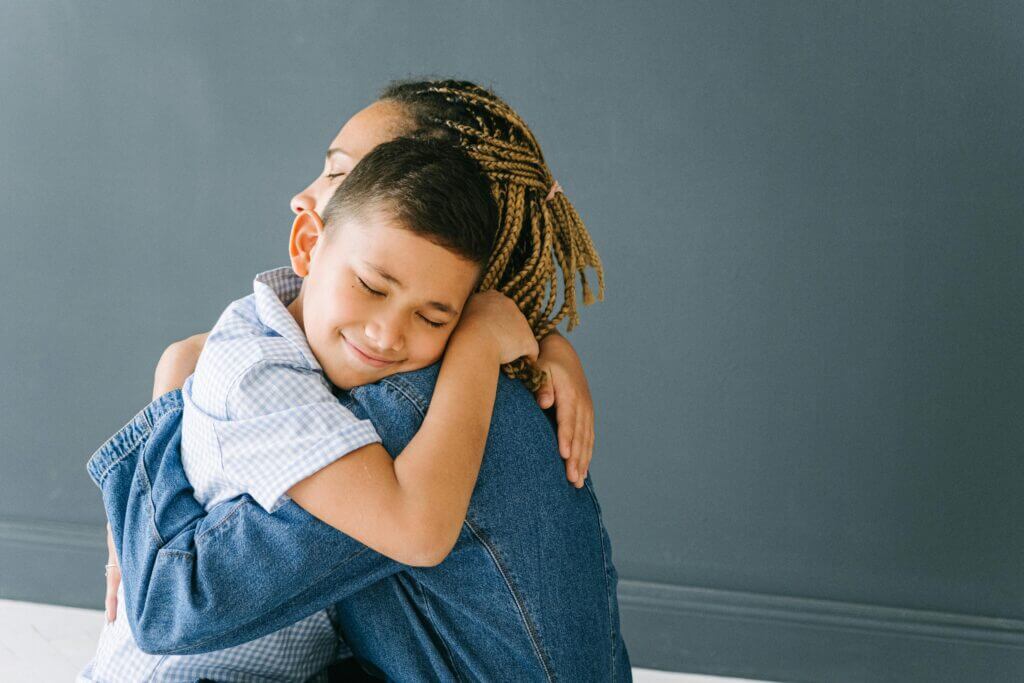 Parent and child connecting through a hug because they spent some time together expressing big emotions, validating feelings, and listening to each other. This therapeutic connection can be a valuable tool in creating a healthy relationship with your child. 