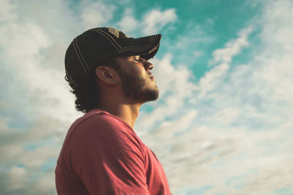 Man Wearing Black Cap With Eyes Closed Meditating. This meditation and mindfulness practice can lead to a healthier you. You may notice a reduction of stress, reactivity, and an increase in calmness and productivity. 