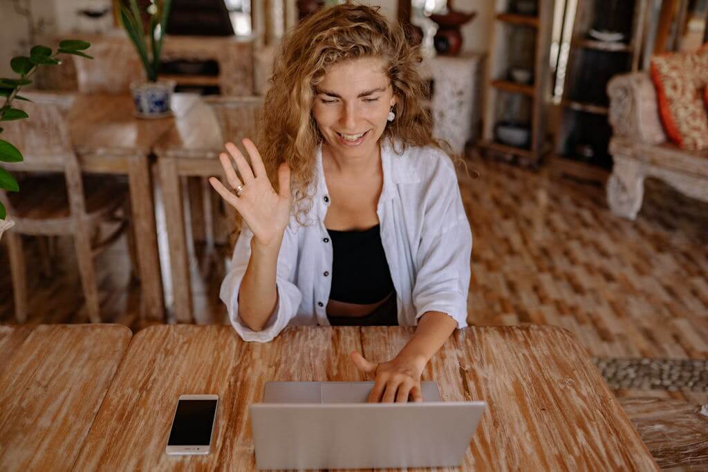 Virtual Brainspotting for Moms with Anxiety | 27517 | 27523 | 28207 | 29455 | Mom waves at her computer as she begins a virtual therapy session at home. Get effective, trauma-informed brainspotting therapy in Chapel Hill, Apex, Charlotte, and Johns Island. Serving | 27517 | 27523 | 28207 | 29455 |