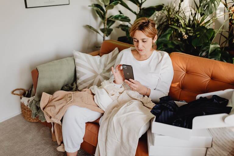 Woman Sitting on a Couch and Using Phone 