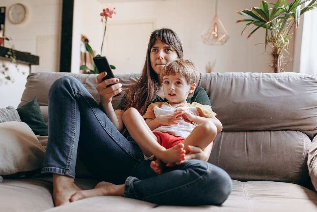 A mother and son sitting on the couch watching TV together in a cozy living room. Attachment Styles are important to know in reflecting your relationship patterns with loved ones. If you're ready to explore what attachment style you have, Online therapy in North Carolina and Online Therapy in South Carolina can help you improve your relationships with loved ones. 