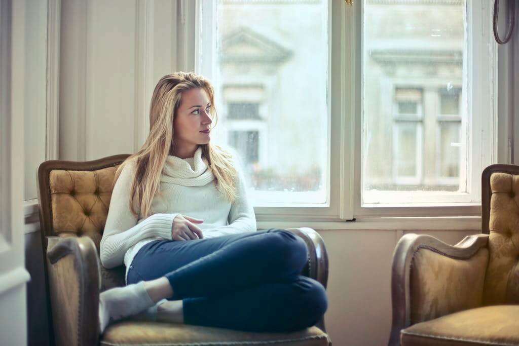 Woman is sitting by the window brainspotting. As an overwhelmed mom it's important to participate in self care. Online therapy for overwhelmed moms is available in North Carolina and South Carolina. 