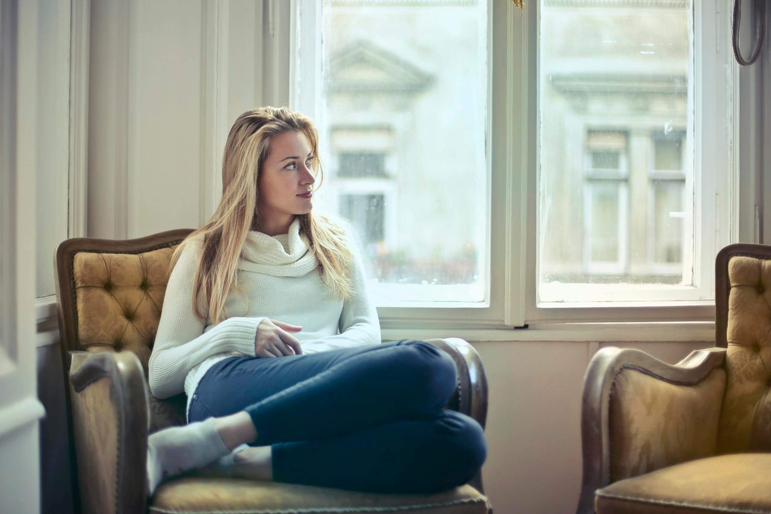 Woman is sitting by the window brainspotting. As an overwhelmed mom it's important to participate in self care. Online therapy for overwhelmed moms is available in North Carolina and South Carolina.