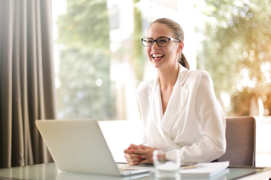 Woman Smiling During Online Brainspotting Session | Brainspotting for Trauma North Carolina | Brainspotting online in South Carolina | Brainspotting Charlotte | 28210 | 27502 | 29615 A woman beams at the camera during an online therapy session, empowered by Brainspotting for trauma. Start your healing journey with Brainspotting online in North Carolina or South Carolina from the comfort of home.