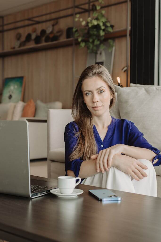 Woman sitting quietly at home in Charlotte, NC, looking thoughtful before starting online therapy with Mosaic Reflections