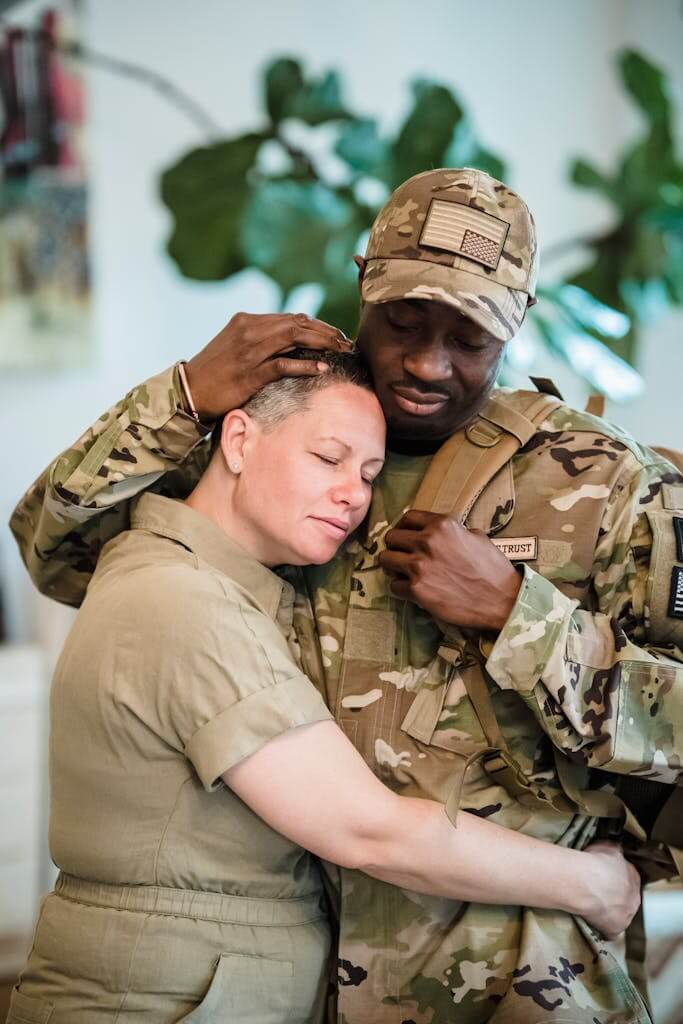 Woman embracing her military partner in Fayetteville NC looking quietly overwhelmed before starting online therapy with Mosaic Reflections | Trauma Therapy | Therapy for PTSD | Overwhelmed Mom | Therapy for Anxiety