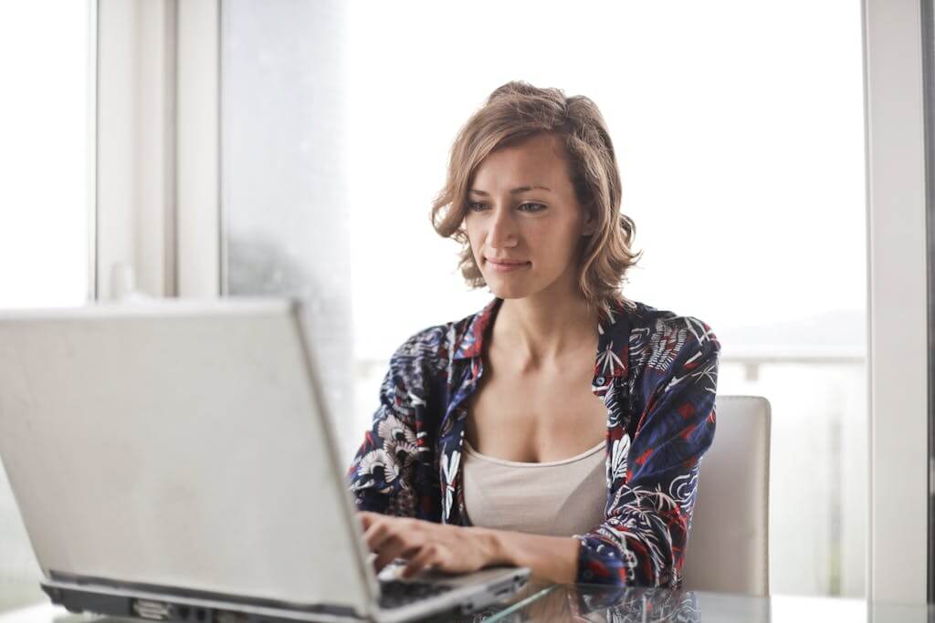 Woman sitting thoughtfully at home in Chapel Hill NC before beginning online therapy with Mosaic Reflections | Therapy for Women | Trauma Therapist | Anxiety Counseling | Brainspotting Therapy